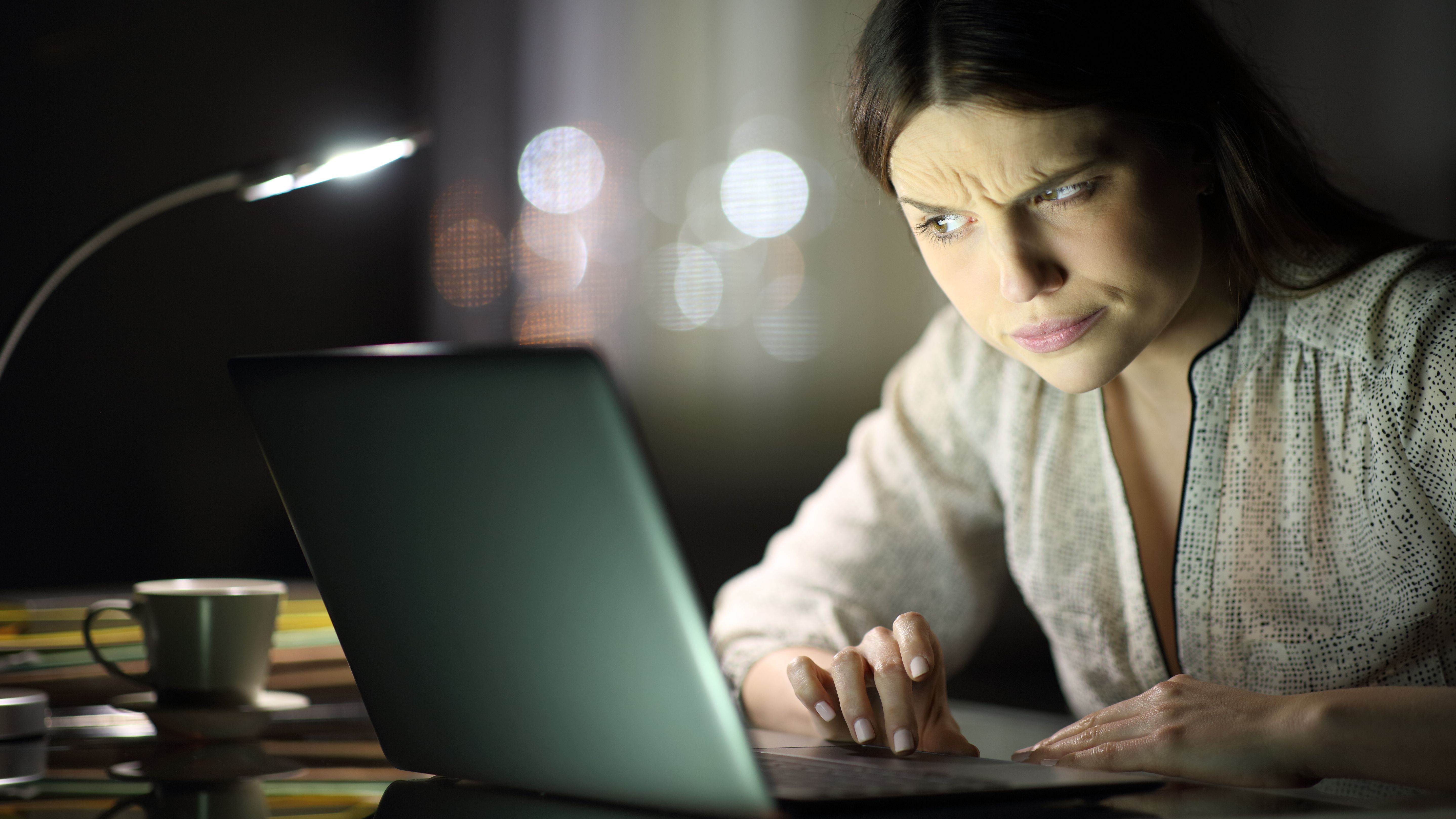 Woman checks suspicious phishing messages on her laptop.