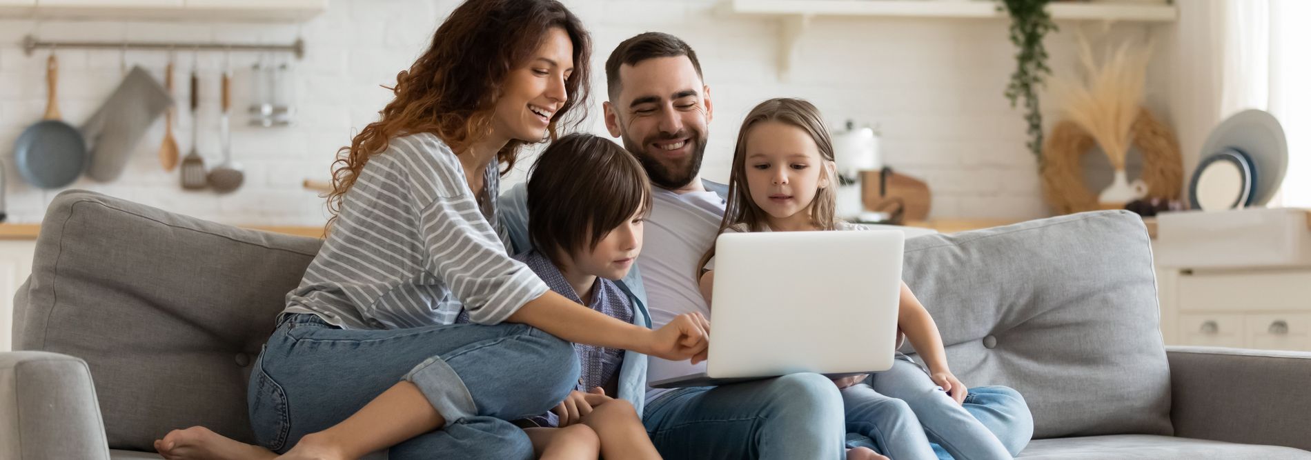 Une famille assise sur le canapé s’informe sur les abonnements Internet les moins chers.