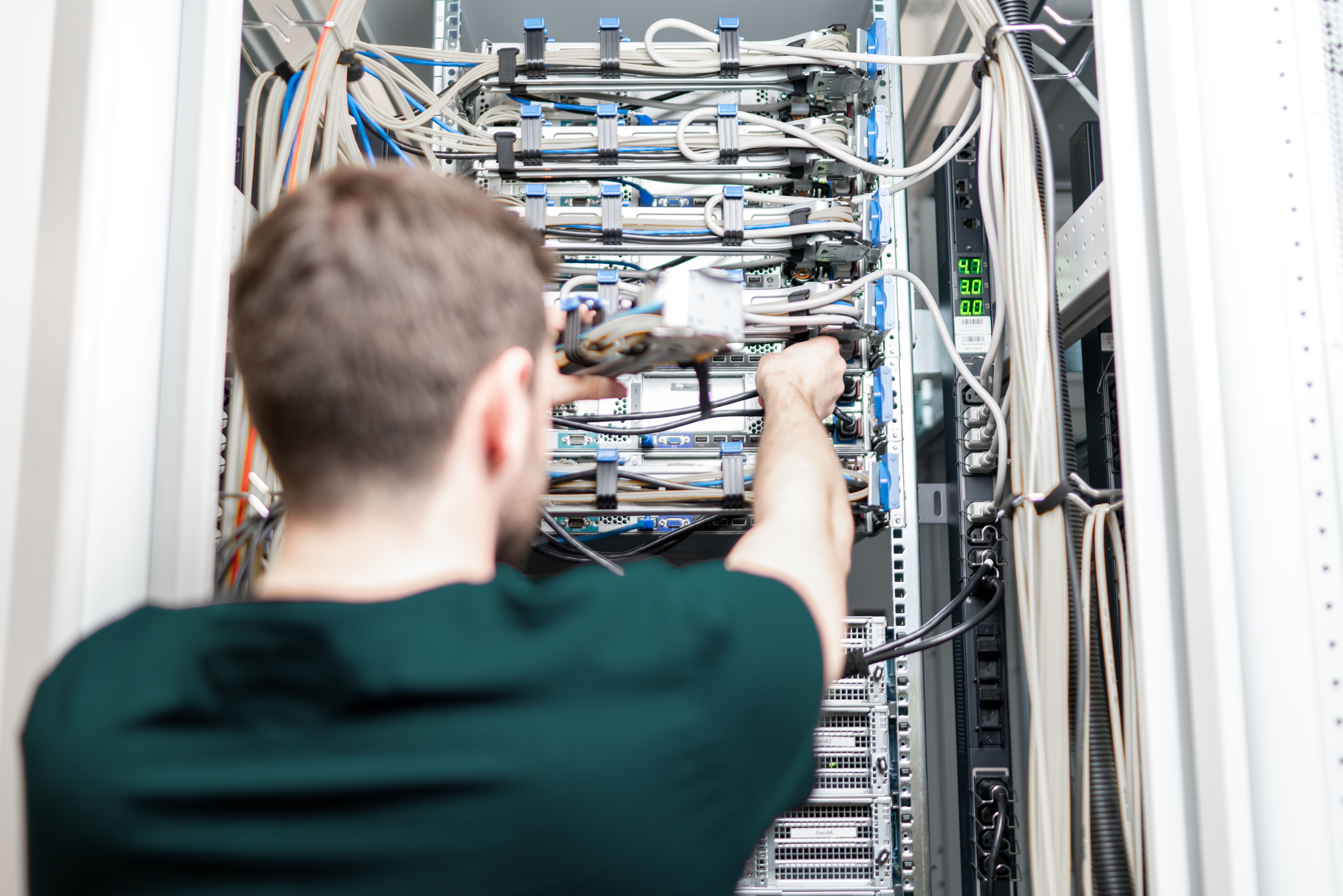 Schaut Mann, der an Server arbeitet, über die Schulter