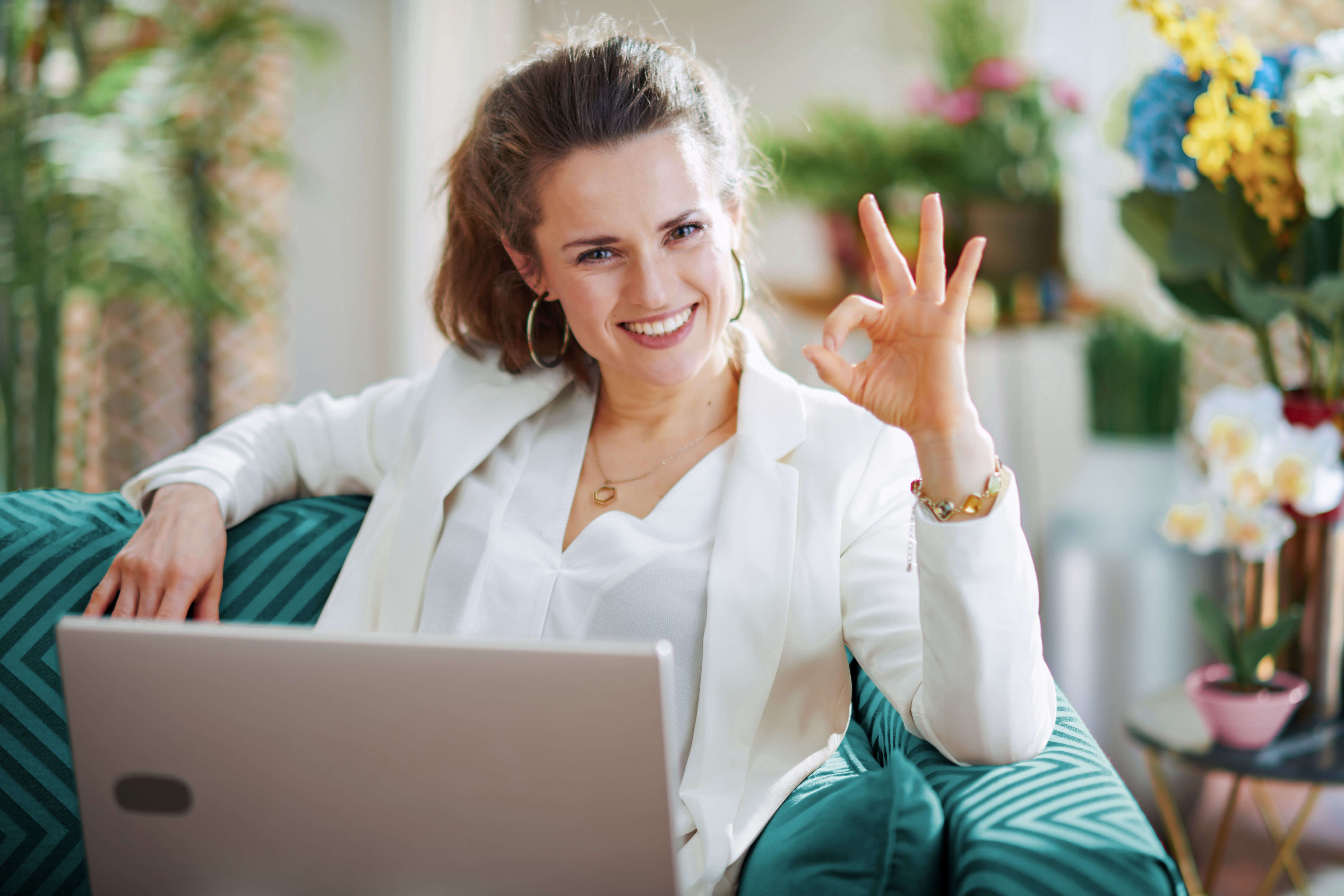 Frau sitzt am Computer und bucht ein Webhosting