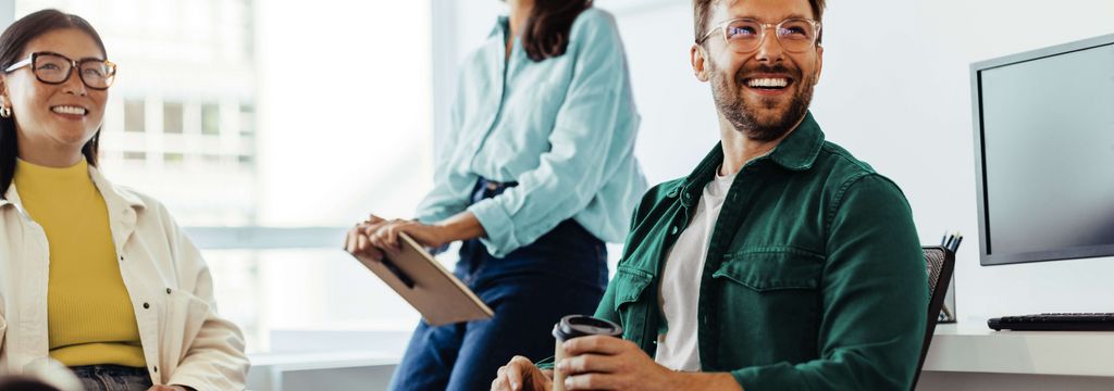 Zwei Frauen und ein Mann lachend im Office