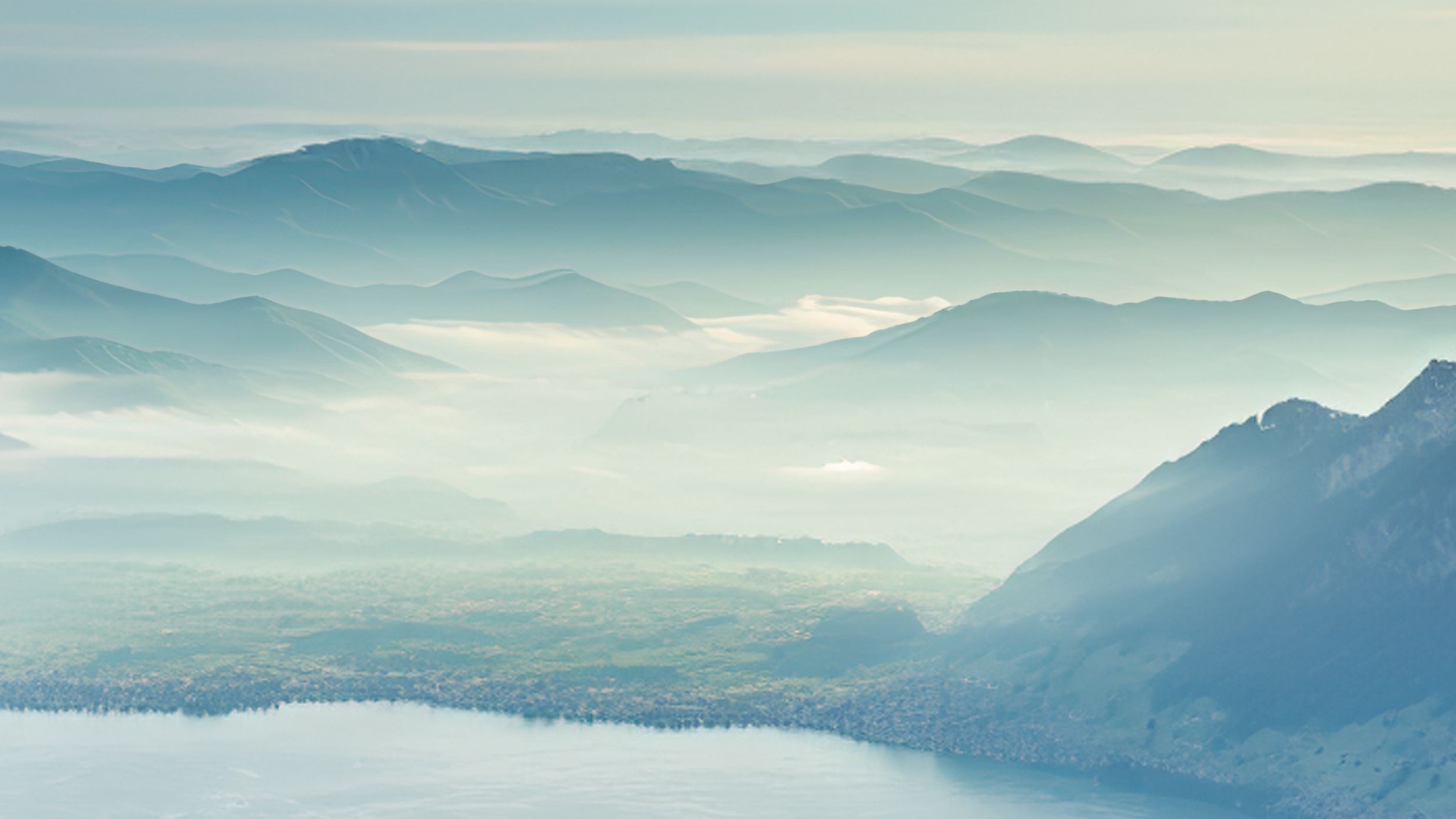 Far-reaching views over wooded hills with light wafts of mist