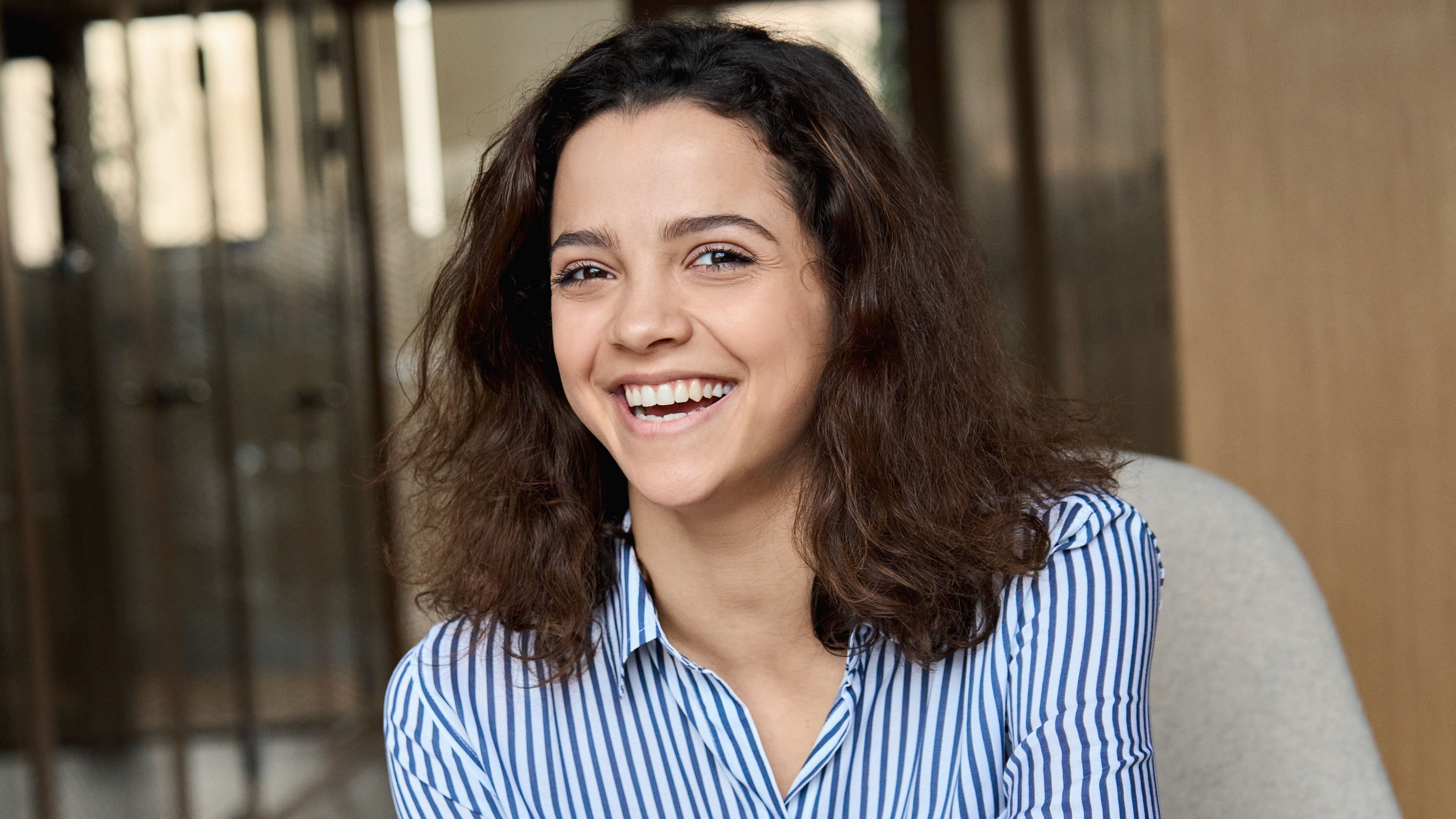 Laughing, seated girl with a mobile in her hand