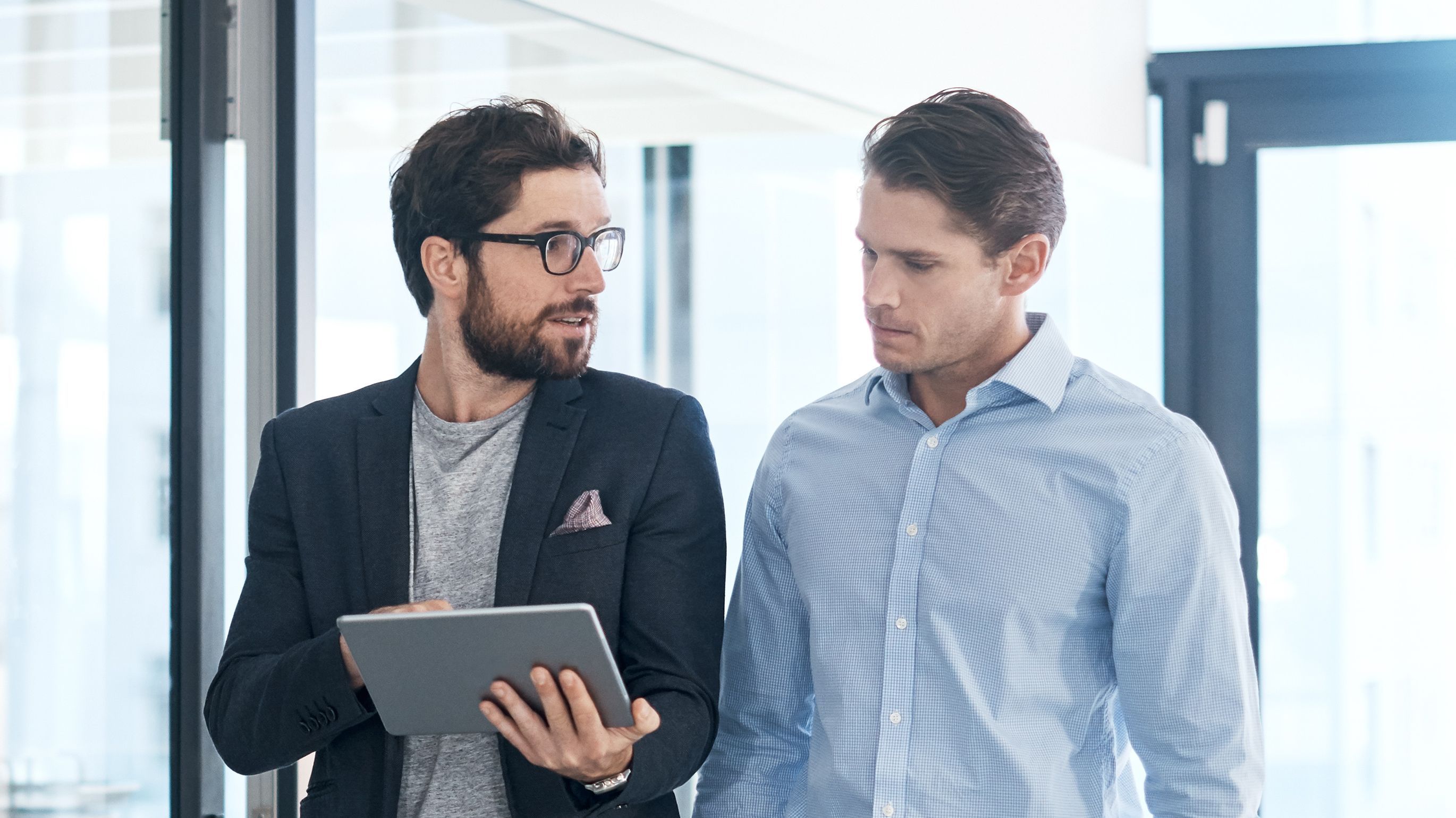 Zwei Männer im Gespräch, die den Flur entlang laufen